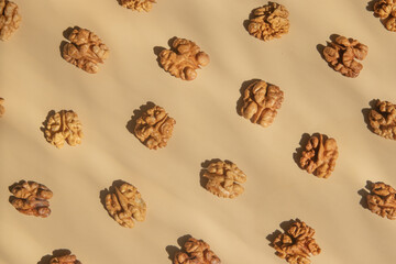 Pattern with peeled halves of walnuts top view. Food abstract background with nuts