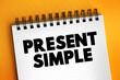 Present Simple - one of the verb forms associated with the present tense in modern english, text concept on notepad