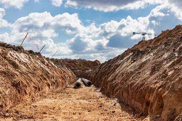 Wall Mural - Insulated pipe. Large metal pipes with a plastic sheath laid in a trench. Modern pipeline for supplying hot water and heating to a residential area.