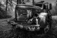 Closeup Shot Of An Old Truck In The Forest In Black And White