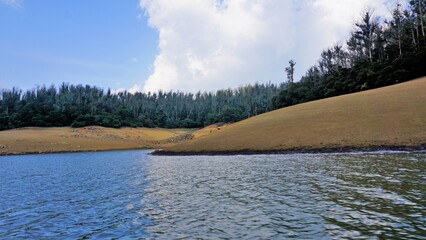 Wall Mural - Beautiful view of Pykara Lake, Ooty, Tamilnadu. Awesome scenery of landscapes of sky,water and green bushes visible from boat ride.