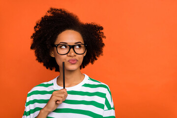 Sticker - Portrait of attractive brainy pensive wavy-haired girl creating plan list copy space learn isolated on bright orange color background