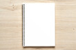 Blank spiral bound notepad mockup template with Kraft Paper cover, isolated on wood background.