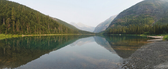 Poster - Scenic shot of a lake that goes through the mountain in Glacier National Park, Montana