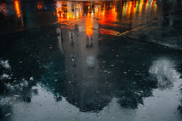 Poster - Wet pavement with reflected building and city night lights