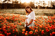 Pregnant model posing for a photoshoot in a field.