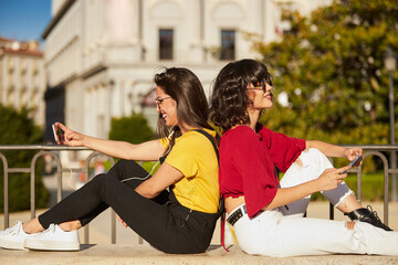 Poster - Two teenager girls sitting and taking selfie.