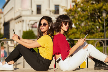 Wall Mural - Two teenager girls sitting andlooking at camera.