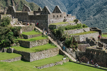 Closeup of Machu Picchu, Peru covered with grass and full of tourists on a sunny day