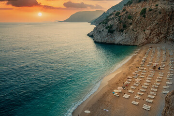 Kaputas beach. People enjoying sun and sea at the Kaputas beach. People enjoying sun and sea at the beautiful turquoise sea and sandy beach of Kaputaş. Sunset over the sea in the background. Mediterra