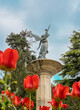 La monumental fuente de la fama en el parque Campo Grande de Valladolid entre tulipanes rojos de su jardín, España