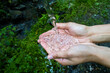 Close-up with the hands of a Caucasian woman in which cold and clean spring water flows. Traveler on a trekking tour enjoying natural and pure water. 
Tourist drinking water from the spring.