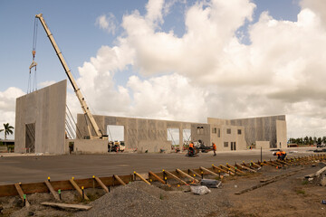 Workmen completing the foundations of a tilt-up warehouse being constructed of prefabricated concrete panels.