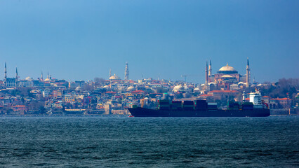 Wall Mural - Container ship in Bosphorus with in Background Hagia Sophia. Istanbul, Turkey.