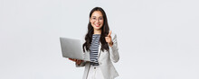 Business, Finance And Employment, Female Successful Entrepreneurs Concept. Smiling Pleased Businesswoman Praise Coworker Who Made Good Point, Pointing Finger Camera Satisfied, Hold Laptop