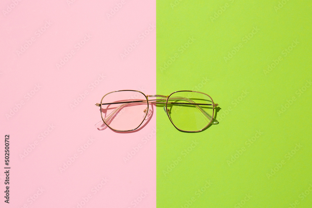 Stylish eyeglasses on color background