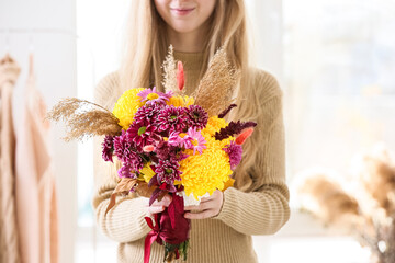 Woman with beautiful autumn bouquet indoors, closeup