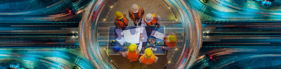 Holding hands top view of Architectural engineers working on solar panel and his blueprints with Solar photovoltaic equipment on construction site. meeting, discussing, designing, Expressway top view