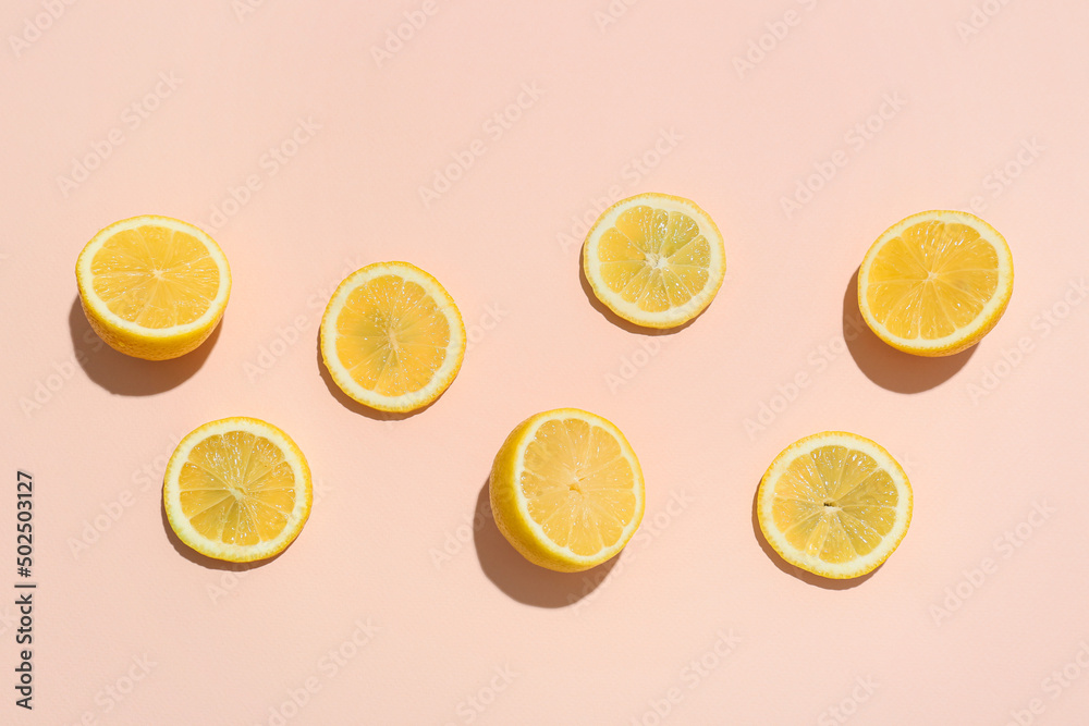 Slices of ripe lemons on light color background, top view