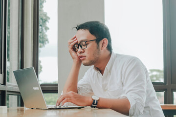 Depressed desperate businessman looking frustrated being overworked sitting at home office desk.