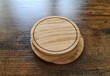Blank coaster stack mockup with wood texture on wooden surface. Circular drink pad pile template