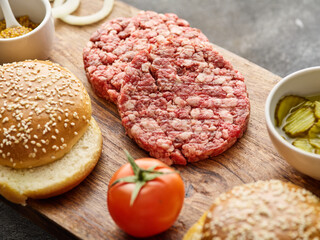 Wall Mural - The raw ingredients for the homemade burger. Burger patties. Raw mince meat cutlet, ground beef and pork with bun. Grey background.