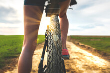 Close Up View Of A Bicycle Tire Protector. Rear View Of A Bicycle Wheel On A Country Road At Sunny Day. Cycling On A Beautiful Sunny Day. Bike Touring.