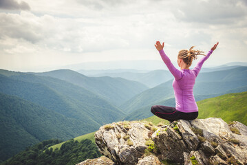 Young woman on the top of mountain