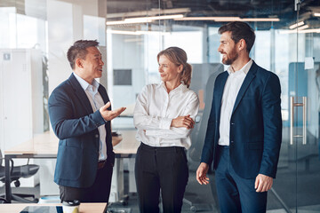 Wall Mural - Young cheerful business people communicate in a meeting room. Teamwork concept