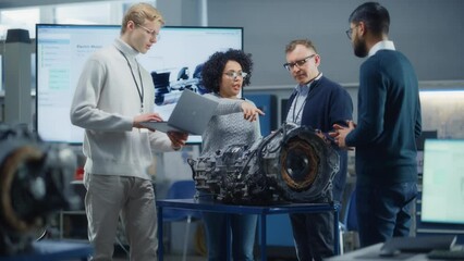 Poster - Diverse Group of Young Specialists Talk with Chief Engineer. Professionals use Laptop Working on Electric Engine Design. Scientific Startup for Futuristic Sustainable Energy Solution. Slow Motion