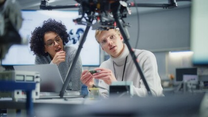Poster - Two Diverse Developers Brainstorming and Programming while Work Together on a New Drone. Colleagues Building, Configuring and Testing Drones. Progressive Technologies Concept. Slow Motion