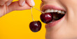 Womans enjoying fresh sweet cherry. Female mouth eating sweet cherry. Closeup female mouth tasting sweet cherry.