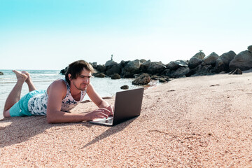 freelancer with a laptop works on a beach