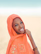 Beautiful young woman smiling and wearing an orange headscarf on a celebration day, photo