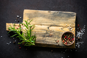 Wall Mural - Food background. Old cutting board, herbs and spices at dark kitchen table. Top view with space for design.