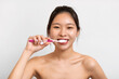 © Prostock-studio - Portrait of young Asian woman brushing her teeth