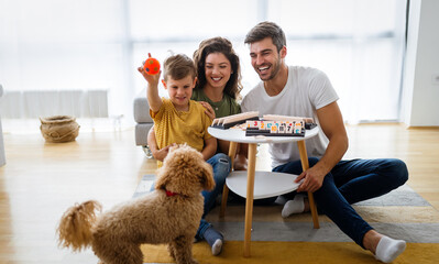 Wall Mural - Happy family having fun, playing board game at home