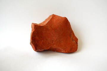 Macro shooting raw red jasper stone rock on white background.