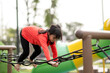 © FAMILY STOCK - summer, childhood, leisure and people concept - happy little girl on children playground climbing frame