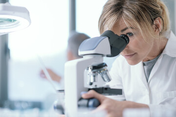 Wall Mural - professional scientist using a microscope