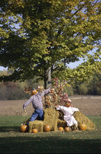 Two Scarecrows And Pumpkins