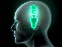 Close-up Of A Man's Head With A Glowing CFL Green Light Bulb Inside
