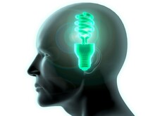 Close-up Of A Man's Head With A Glowing CFL Green Light Bulb Inside