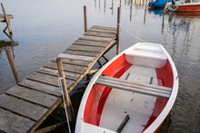 White And Red Boat Roped To The Wooden Pier In The Lake