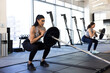 © SuperStock - Woman taking a deep breath while doing barbell squats in gym