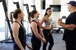 © SuperStock - Three woman standing in a row listening to their fitness trainer before a workout