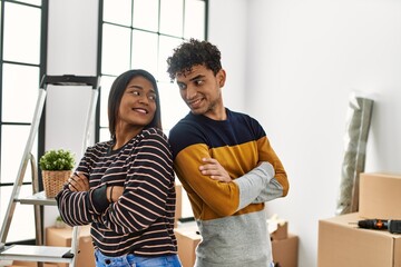 Poster - Young latin couple smiling happy standing at new home.