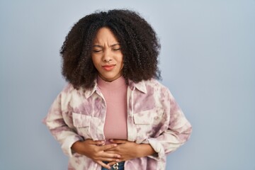 Sticker - Young african american woman standing over blue background with hand on stomach because indigestion, painful illness feeling unwell. ache concept.