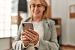 © Krakenimages.com - Middle age businesswoman smiling happy using smartphone at the office.