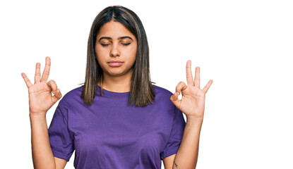 Sticker - Young hispanic girl wearing casual purple t shirt relax and smiling with eyes closed doing meditation gesture with fingers. yoga concept.